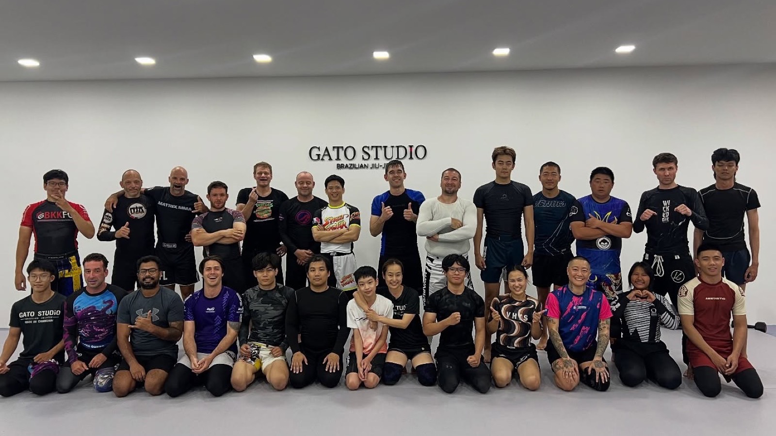 คลาสโนกิของ Gato Studio BJJ ถ่ายรูปรวมกันหน้าโลโก้ยิมที่เชียงใหม่